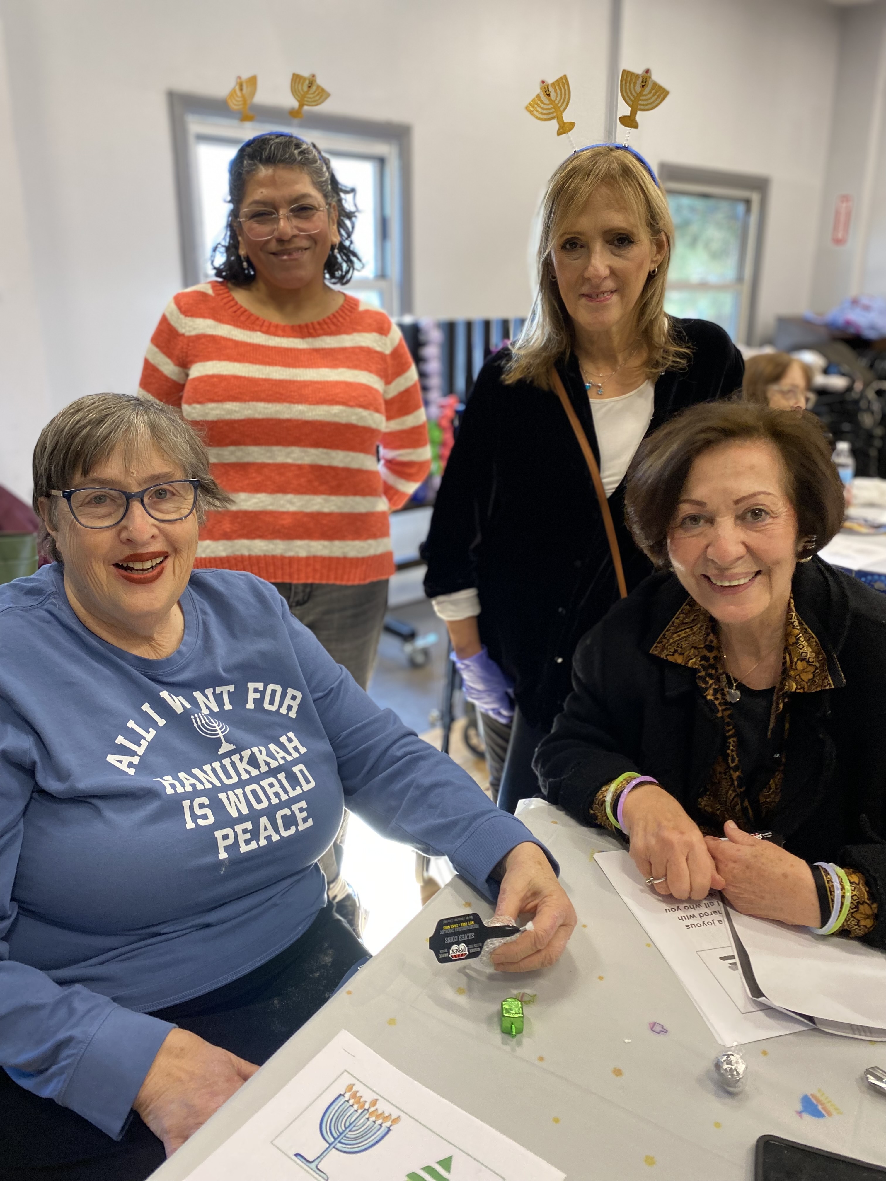 A group of older women posing for a photo at a table in Central Queens Adult Center.