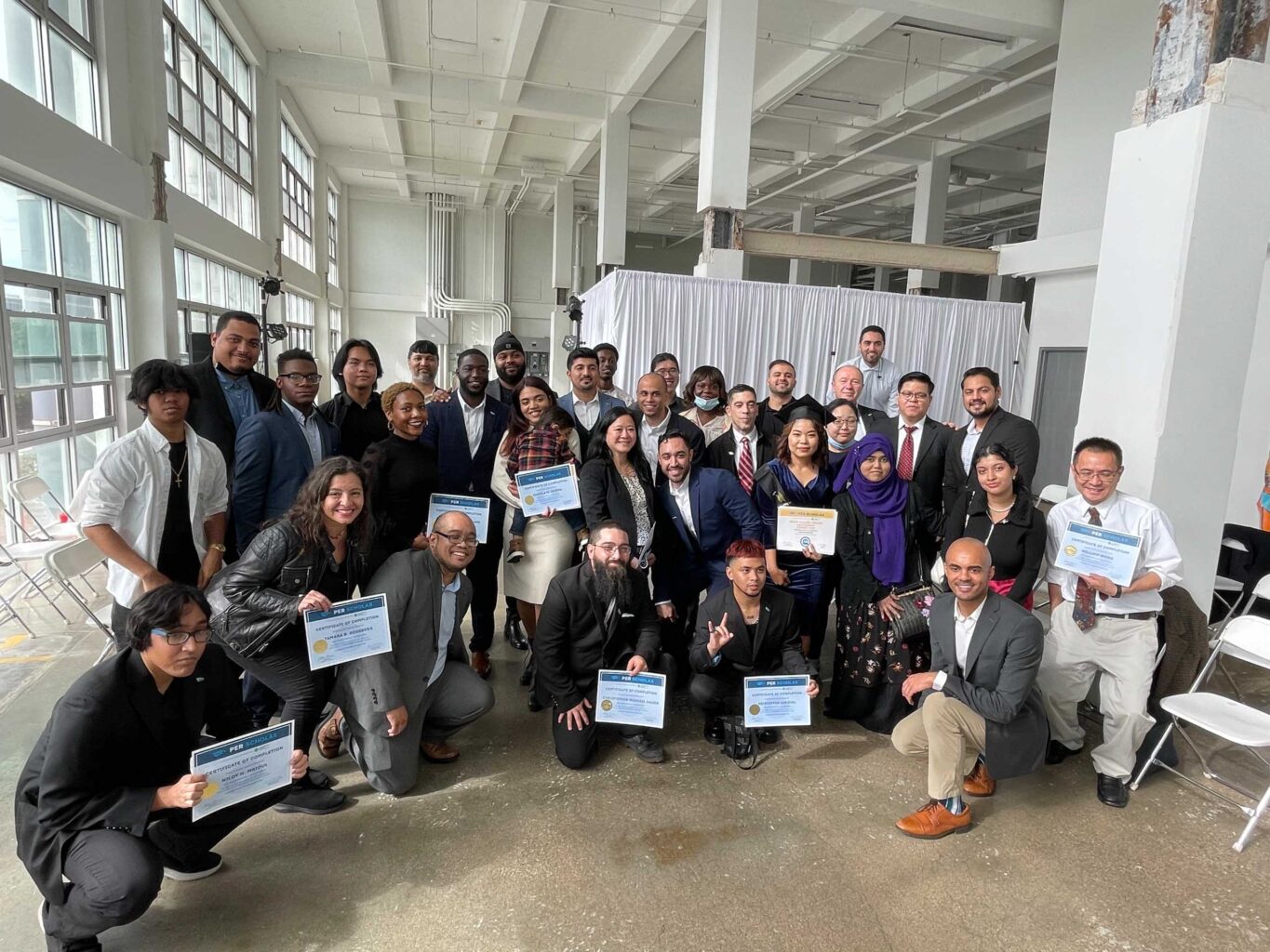 A group of people posing for a photo with their certificates.