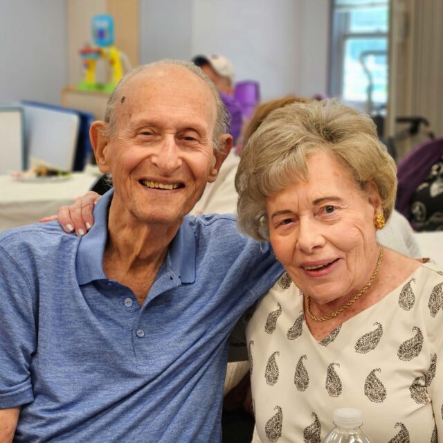 An older couple posing for a photo at a party.