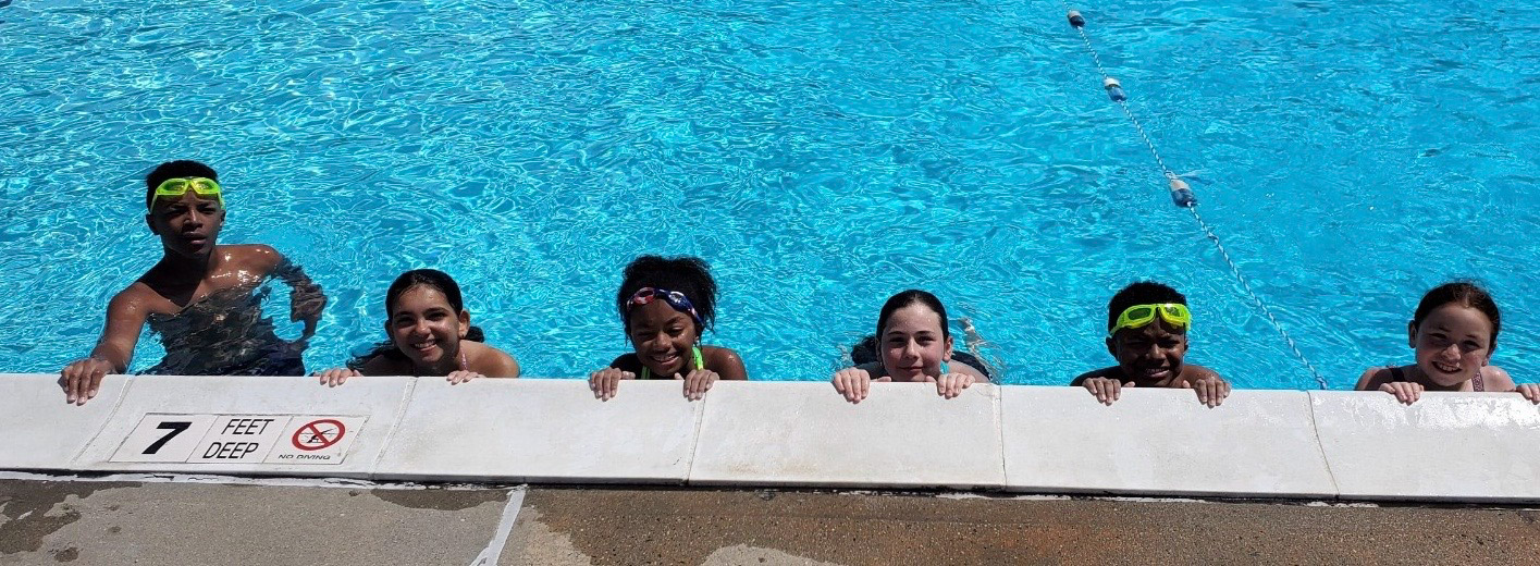 A group of kids in goggles in a swimming pool.