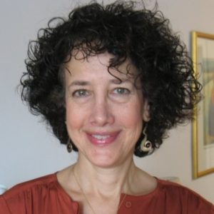 A woman with curly hair smiling for the camera.