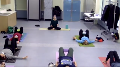 A group of people doing yoga exercises in a hospital room, catering to the demand for exercise videos.